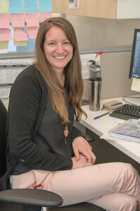 A woman sits at a desk in an office