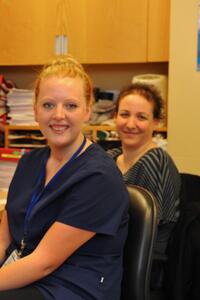Three women sit at desks