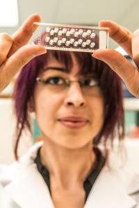 A researcher examines a glass slide