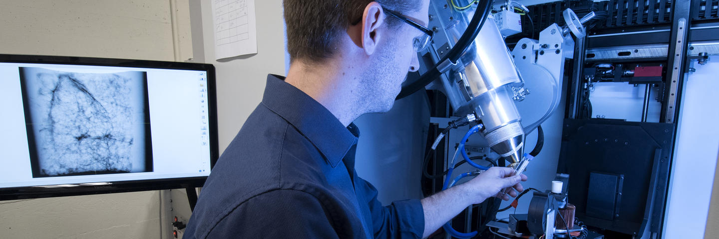 A man stands in front of a machine